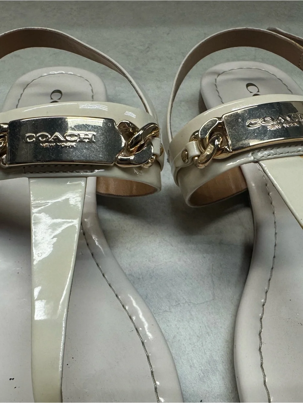 Coach Ivory Patent Leather T‑Strap Sandals with Gold Plaque